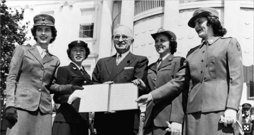 A photo of President Truman and four military women in 1948, holding the Armed Forces Integration Act he signed into law.