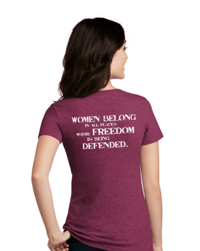 Back view of a woman in a raspberry color shirt that says Women Belong in all places where freedom is being defended