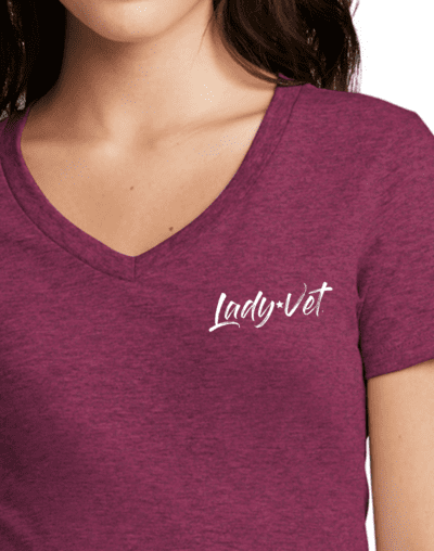 A close up of a woman in a raspberry color Lady Vet V-neck tee